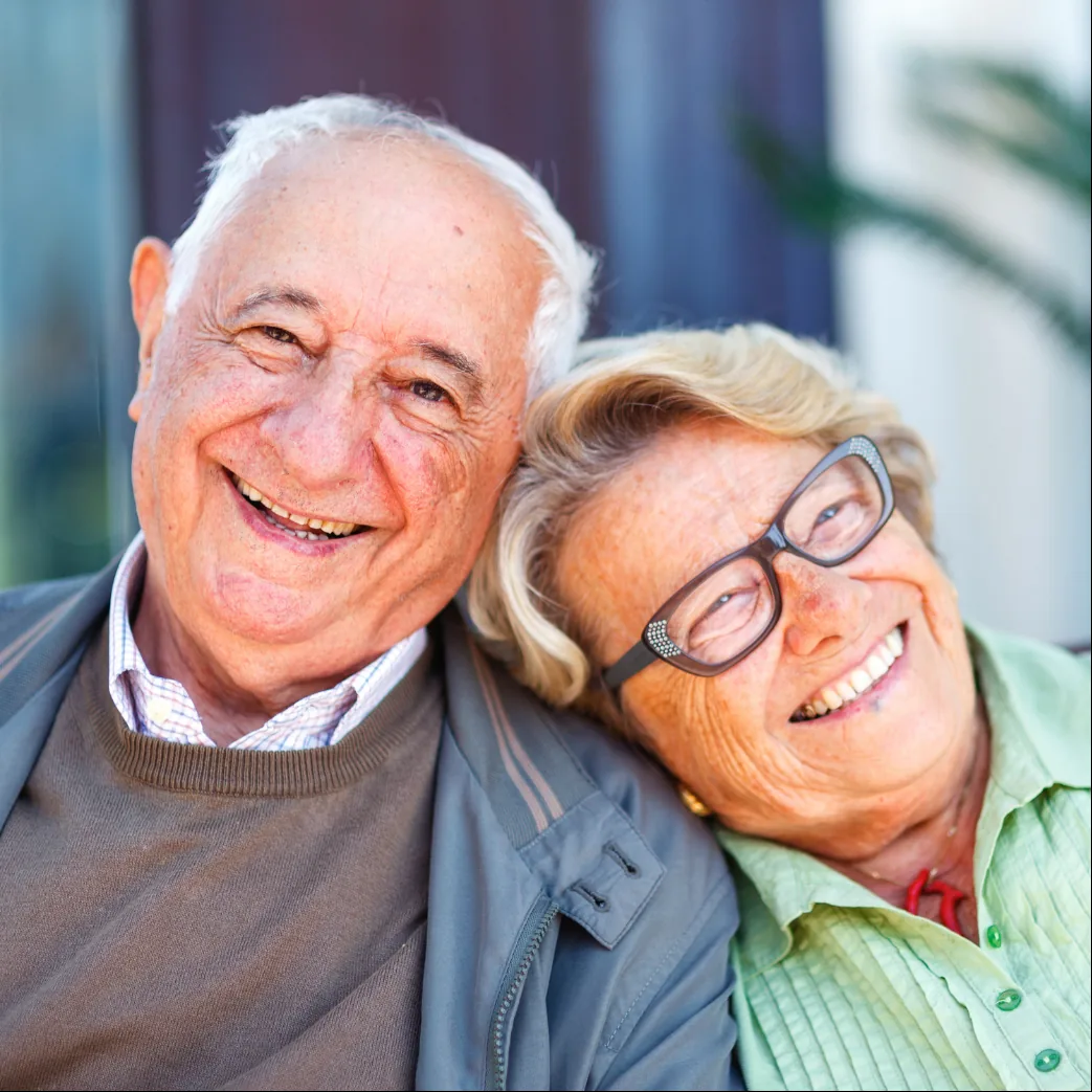 Smiling older couple sitting together outdoors